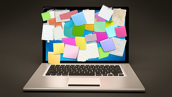 Laptop mit Post-Its auf dem Bildschirm