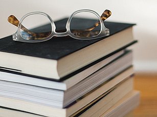 Bücherstapel mit Brille